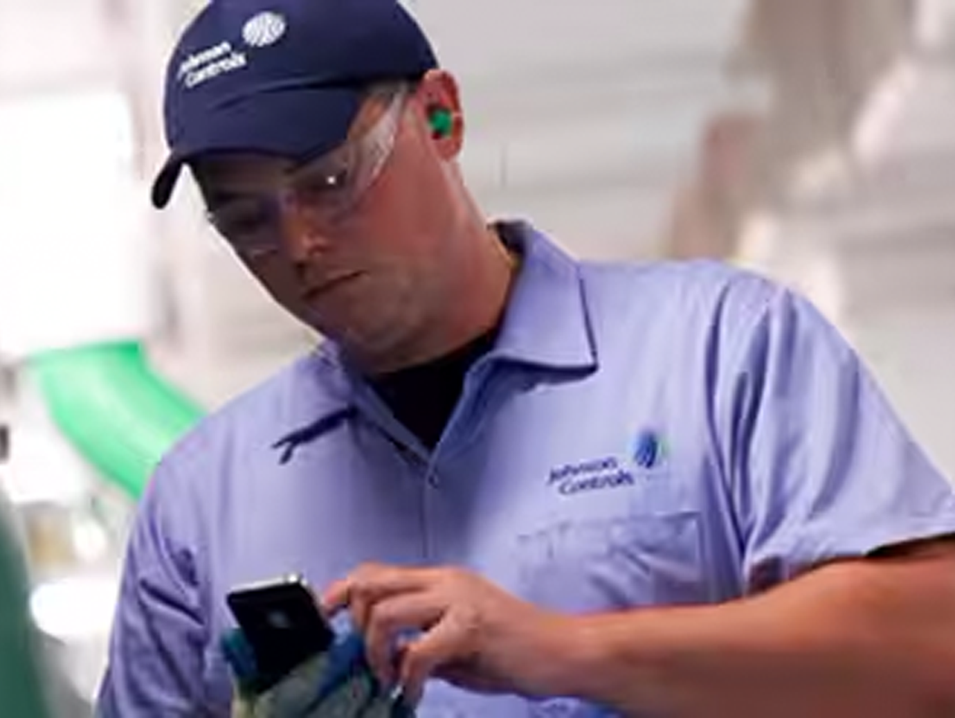 Close-up of Johnson Control employee checking his mobile