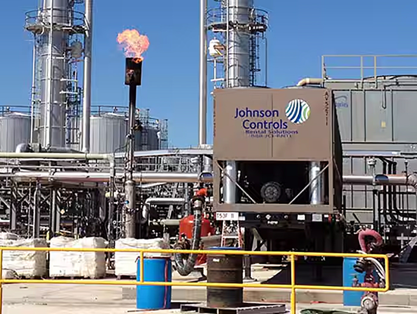 Displays an industrial facility with Large piece of equipment displaying Johnson Control logo
